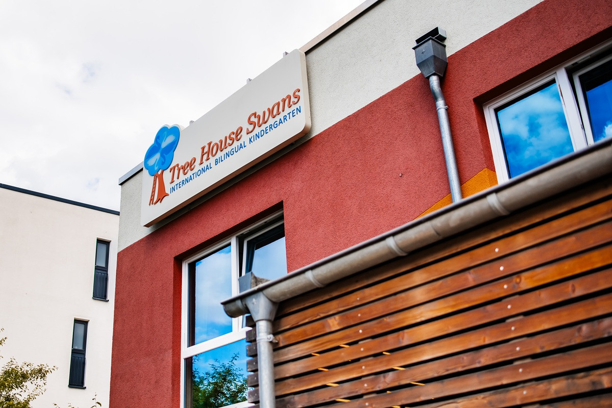 Außenansicht des Kindergartens mit dem Schild "Tree House Swans - International Bilingual Kindergarten".